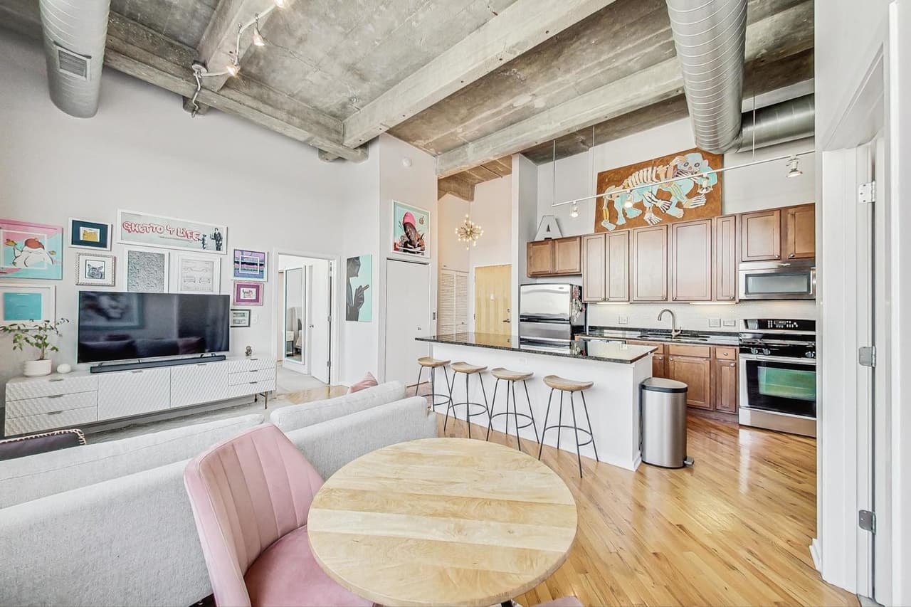 Main living space with kitchen island, dining table, and high ceilings