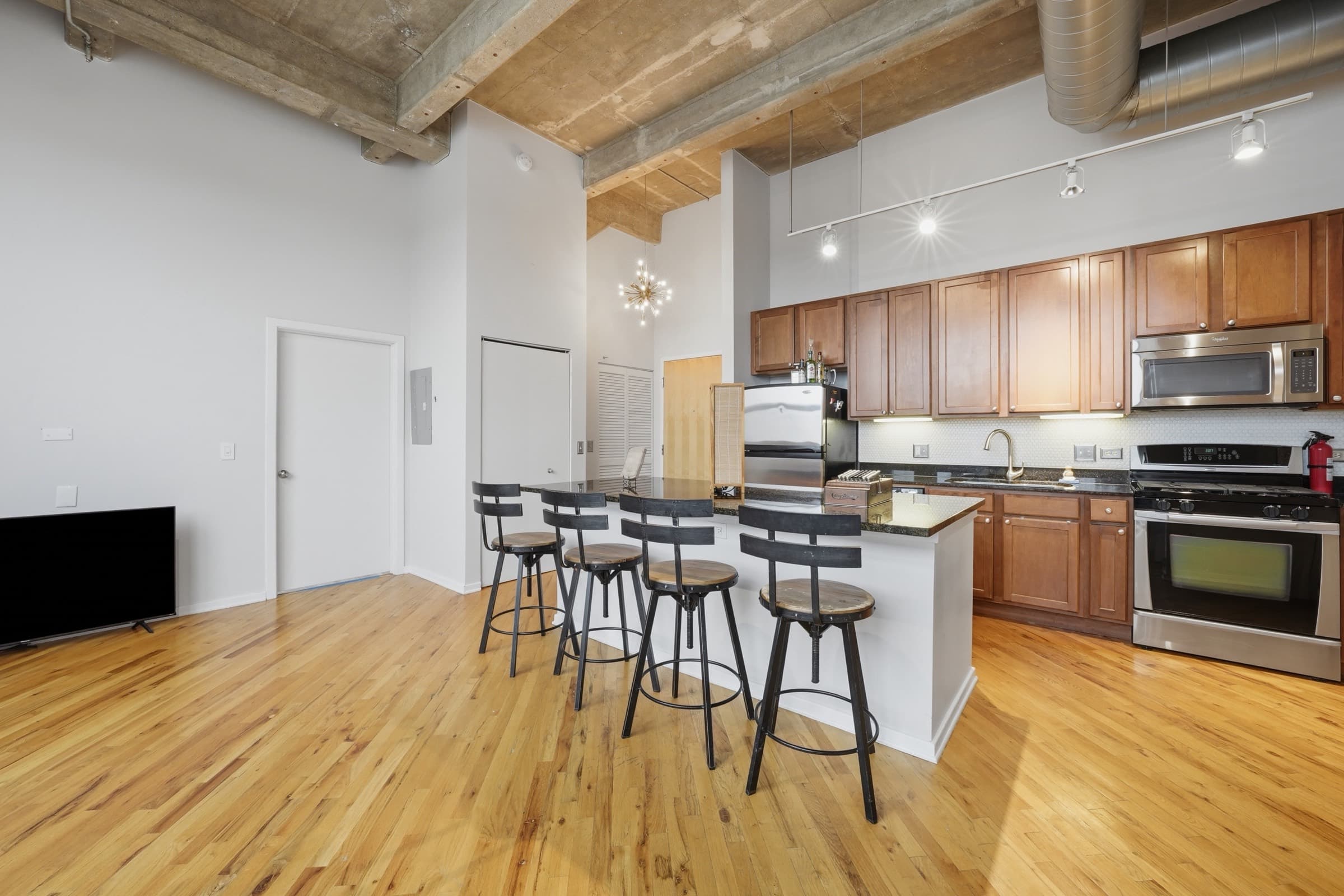 Kitchen island with seating, stainless appliances and track lighting