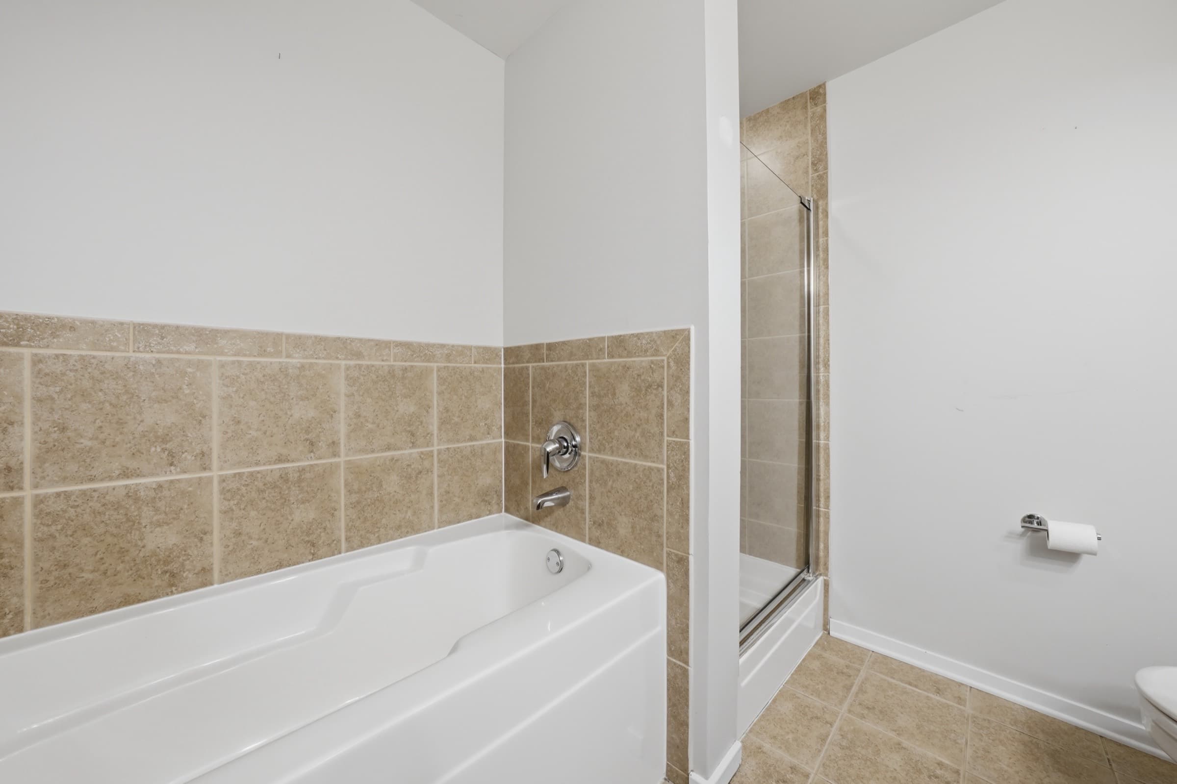 The second bath with a soaking tub and tiled surround