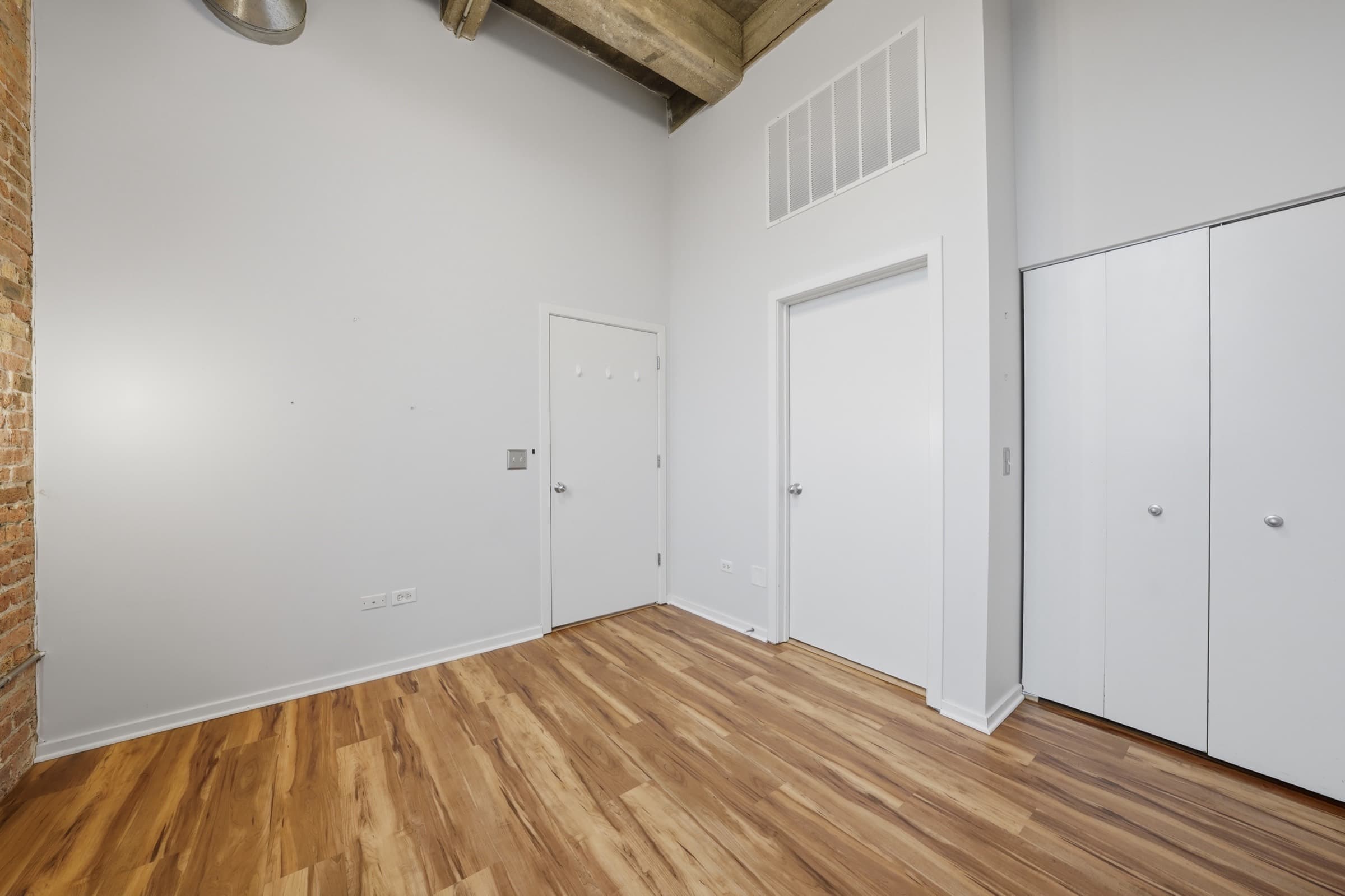 The walk in closet with its doors, off the primary bedroom